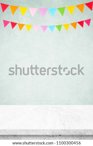 Colorful party flags hanging on white wall and white cement table background, birthday, anniversary, celebrate event, festival greeting card background