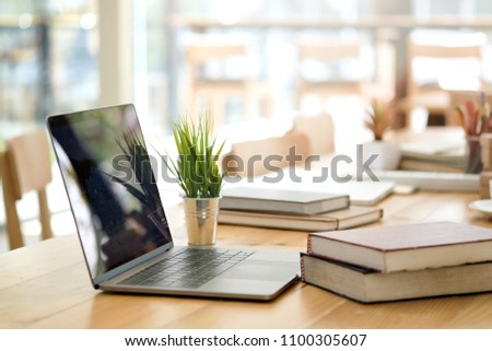 Desk with laptop, books and business office background. Royalty-Free Stock Photo #1100305607