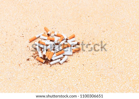 Pile cigarettes broken on table terrazzo flooring yellow background. health care concept stop quitting smoking.