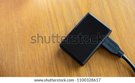 Black mini USB hub on wooden table background, technology concept