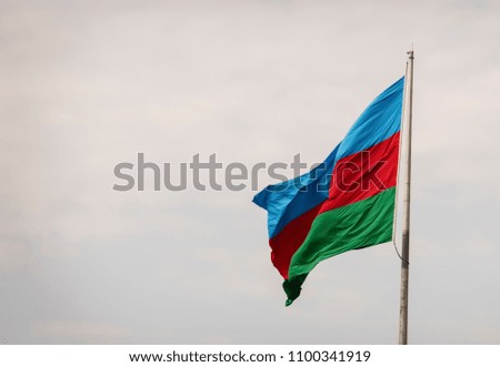 flag of the country Azerbaijan developing in the wind against the blue sky