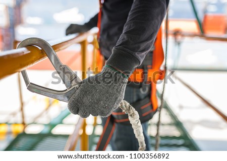 Construction worker wearing safety harness and safety line working on construction Royalty-Free Stock Photo #1100356892