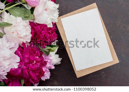 Workspace. Wedding invitation cards, craft envelopes, pink flowers and green leaves on white background. Overhead view. Flat lay, top view invitation card. ink pen with copy space. mockup with peonies