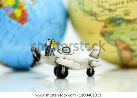 Miniature people : business team, couple of love sitting on airplane wing for travel around the world.