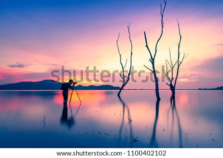 Silhouette of a photographer like to travel and photography Royalty-Free Stock Photo #1100402102