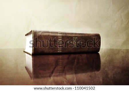 A large old dictionary sitting on a desk