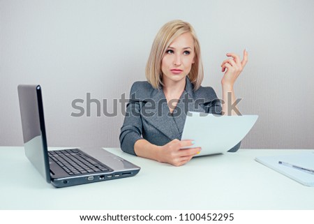 attractive smart blonde multitasking woman (business lady) in stylish business suit working with laptop and throws lumps of paper (draft) in office . business concept and deadline