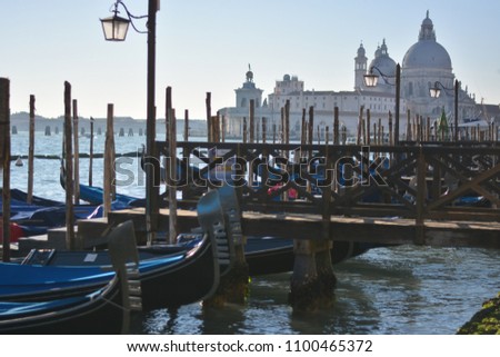 The gondolas moored on the lagoon of San Marco with the cathedral of Santa Maria Della Salute in the background