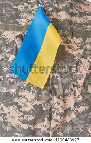 Ukrainian flag on military uniform. Patriotic soldier concept. Close up.