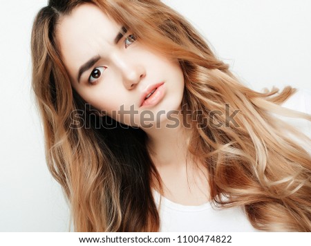 Young beautiful curly woman posing with white t-shirts, ower white background