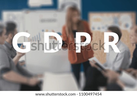 Blurred photo of a businesswoman giving a presentation about data protection policies behind white GDPR text.