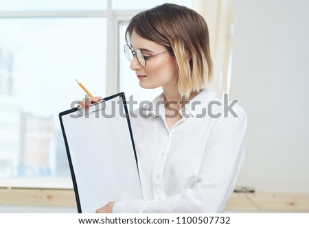 woman looks at a blank sheet of paper in a folder                              