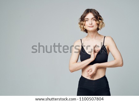 woman in top in leggings gestures with hands                           