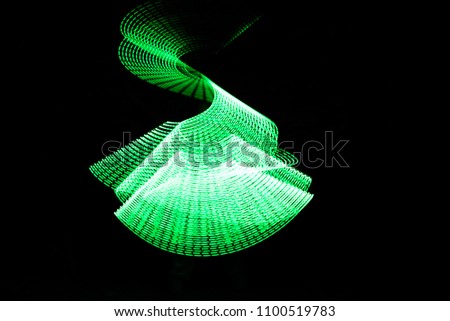 Green Light Painting, long exposure photography, loop and swirl against a black background