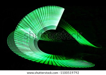Green Light Painting, long exposure photography, loop and swirl against a black background