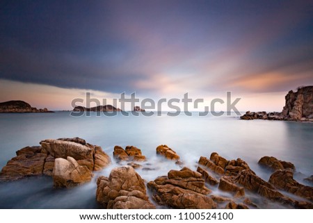 Long exposure sea landscape photo at beautiful bay with rocks on a front