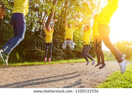 Team fitness by jumping in the group as teambuilding event Royalty-Free Stock Photo #1100531936