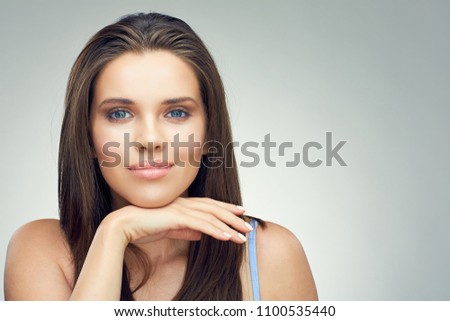 Face portrait in beauty style of smiling teenager girl touching face with hand. Isolated studio background.