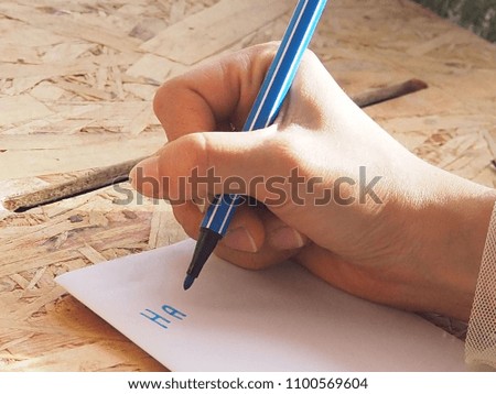 A woman holding a pen writing a note on a white note. Learn to take notes concept