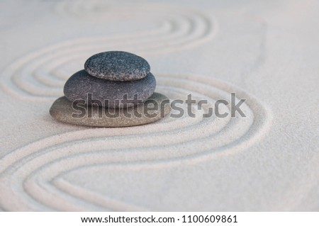 Pyramids of gray zen stones on light sand. Concept of harmony, balance and meditation, spa, massage, relax Royalty-Free Stock Photo #1100609861