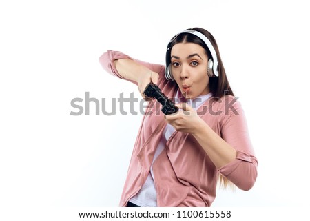 Young girl gamer in headphones with joystick playing computer game. Isolated on white background. Studio portrait.