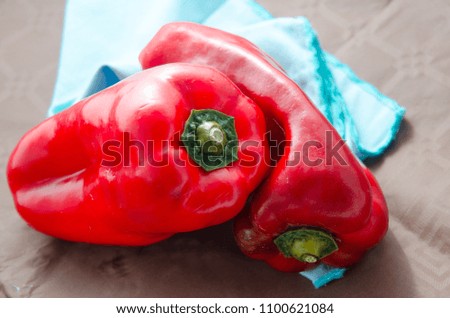 composition of red peppers on brown background and blue napkin