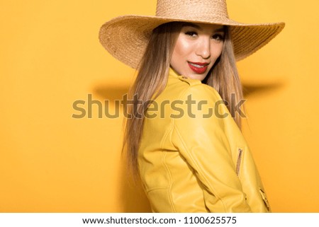 stylish asian female model in straw posing on yellow background 