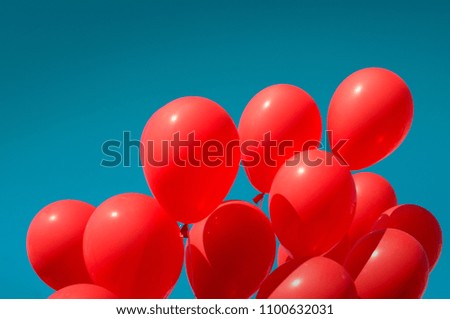 Red balloons on the background of aquamarine sky