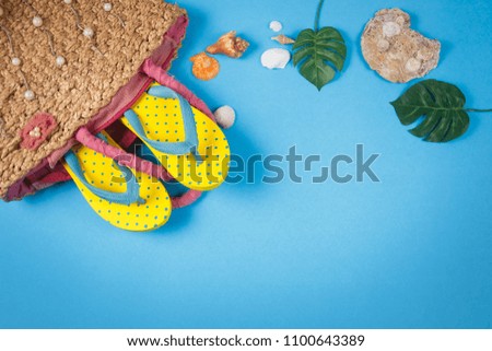Yellow sandals in woven handbags on blue color background, Summer holidays accessories . flat lay photo