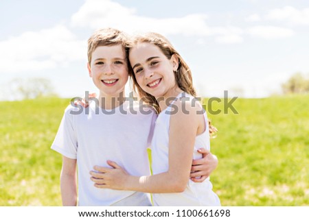 Portrait of two children boy and girl brother in park in summer and having fun