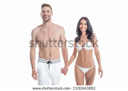 beautiful cheerful couple in swimwear holding hands, isolated on white