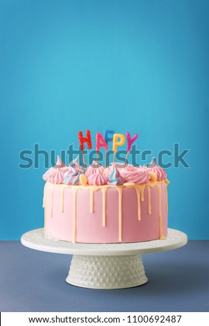 Birthday cake isolated on a blue background. Birthday party decorated cake with candles and sparkles. Copy space