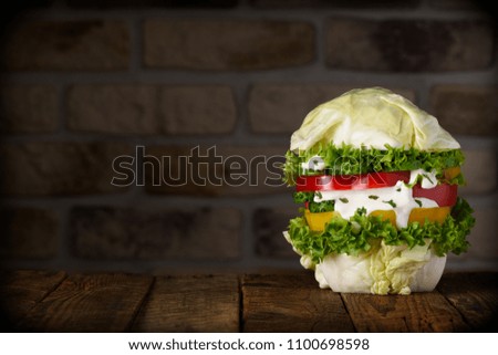 Big vegan burger on wooden table still life with copy space. Pure organic vegetable hamburger concept.