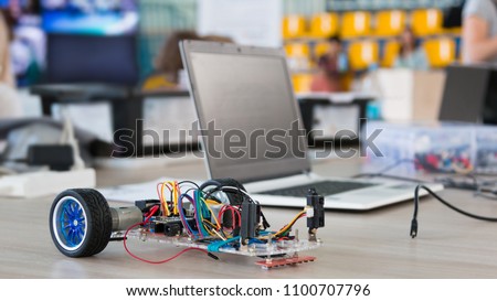 A metal car robot and an electronic board that can be programmed. Robotics and electronics. Laboratory. Mathematics, engineering, science, technology, computer code. STEM education.  Royalty-Free Stock Photo #1100707796