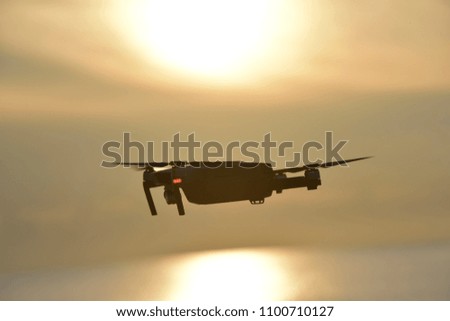 Drone flying in the sunrise sky .The drone with the professional camera takes pictures.