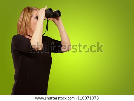 Women looking through binoculars isolated on green background