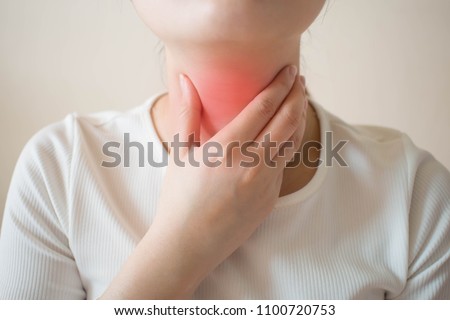 Sick women suffering from sore throat on gray background. Causes of throat pain include flu, common cold, bacterial infections, allergies, smoke, GERD or tumor. Health and medical concept. Close up. Royalty-Free Stock Photo #1100720753