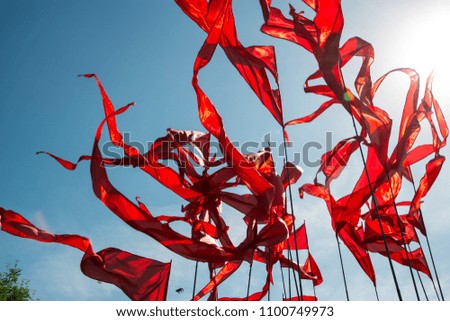red flags . triangular flags in the wind on a blue sky in the backlight sun