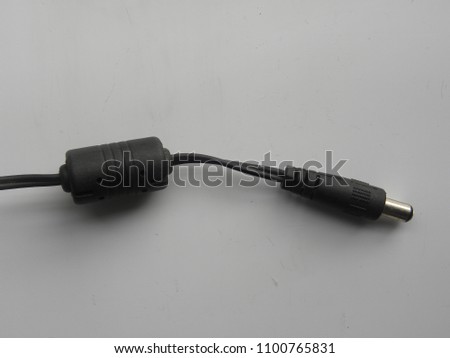 Black color male jack and ferrite bead inductor of power plug adapter on white background
