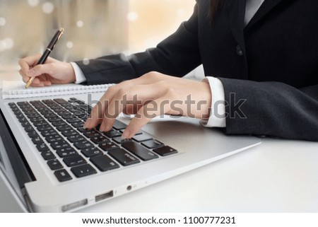 Business woman working on a laptop computer in the office. White room Bokeh background. Email Concept Business women are sending mail. woman using a keyboard.Type documents using the keyboard 