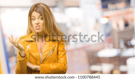Beautiful young woman irritated and angry expressing negative emotion, annoyed with someone at restaurant