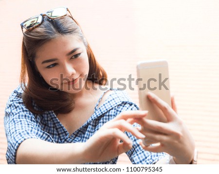 Asian pretty women use her mobile phone for selfie