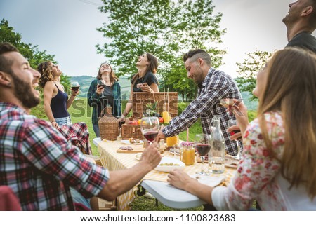 Group of friends making barbecue in the nature - Happy people having fun on a pic-nic in the countryside