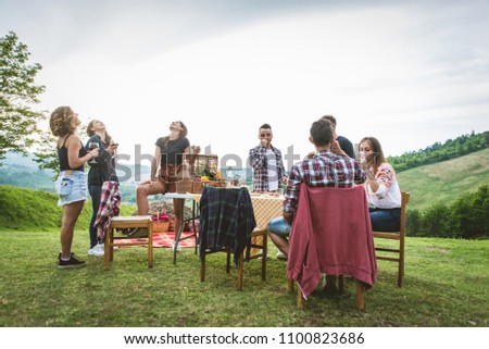 Group of friends making barbecue in the nature - Happy people having fun on a pic-nic in the countryside