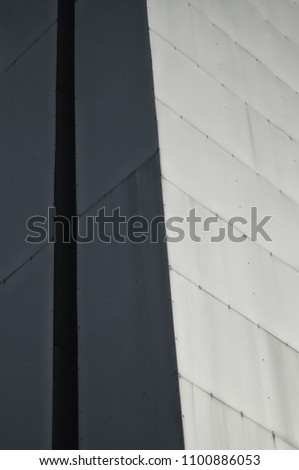 Fragment of the angle of modern high-rise structure in gray color for background or texture in design