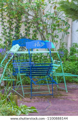 Table and chairs in the garden, vertical picture
