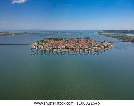 Aerial scenic view of the famous island - town of Aitoliko in Aetolia - Akarnania, Greece is situated in the middle of Messolonghi Lagoon and it is known as the Little Venice of Greece. Royalty-Free Stock Photo #1100921546