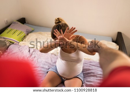 Woman victim of domestic violence and abuse. Husband intimidates his wife. Scared woman is looking on drunk man on foreground. Having bruises on her pretty face.Sexual abue concept. Domestic violence  Royalty-Free Stock Photo #1100928818