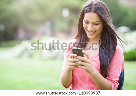 A beautiful hispanic college student texting on her cellphone