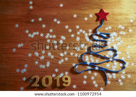 Sigh symbol Christmas Tree from a lot colorful confetti, lace and red star toy on style wooden texture background. Empty copy space for inscription. Idea of happy new year 2019 holiday.merry christmas